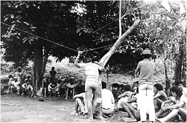 Grupo de pessoas reunido à sombra das árvores em Trindade, em fotografia antiga