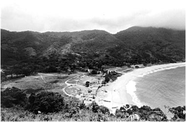 Fotografia em preto e branco da enseada e da ocupação da vila de Trindade